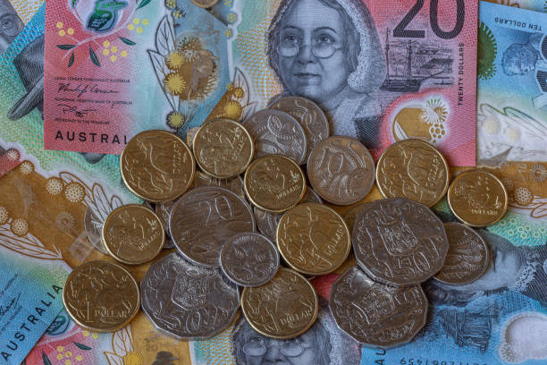 Australian dollar bills and coins Close-up on a spread of Australian dollar coins of various denominations over dollar banknotes, with main focus on a 20 dollar bill. australian 5 cents stock pictures, royalty-free photos & images