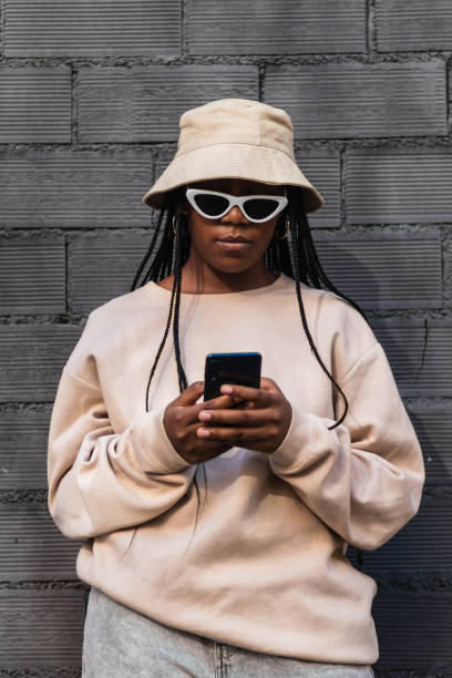 istock Black woman using smartphone near brick wall 2169546997