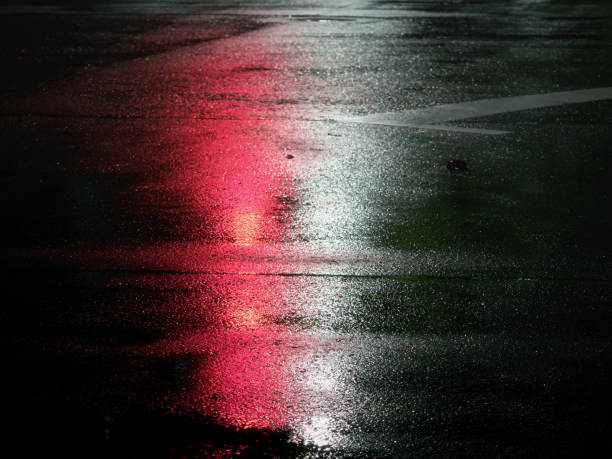 istock Reflection of Traffic light  on a wet road at night 2169547481
