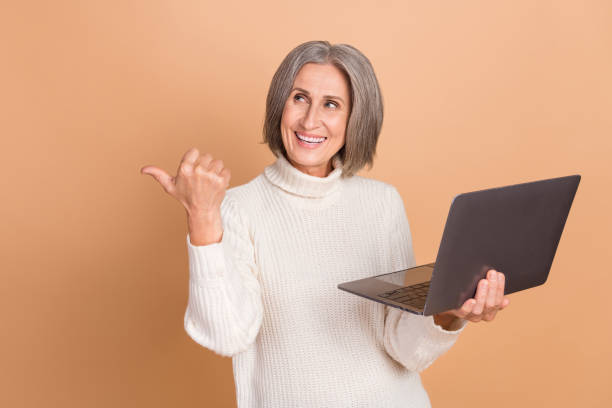 istock Photo of shiny dreamy lady dressed white sweater working modern device thumb empty space isolated beige color background 2169548387