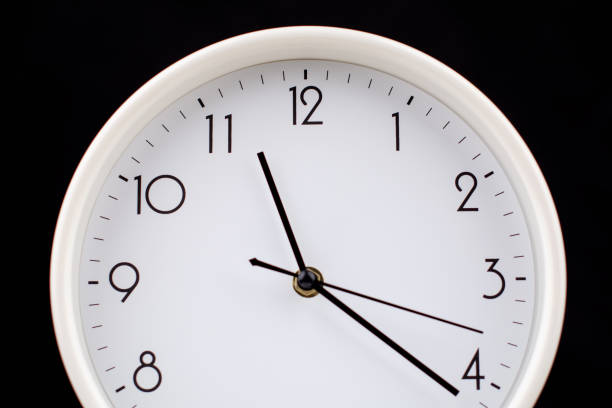 First seconds of the New Year. Round clock with white dial and hands showing 12 hours or 0:00, to 24. Time management business.