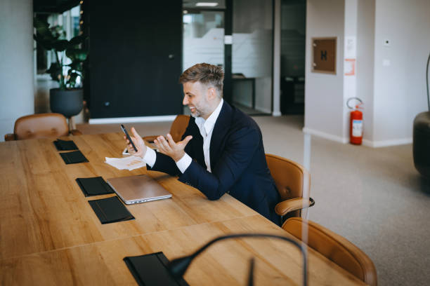 istock Businessman in navy suit gesturing during a video call on smart pnone 2169550632