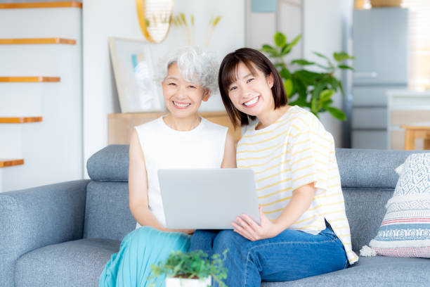 istock Senior woman learning how to use a computer in the living room 2169552014