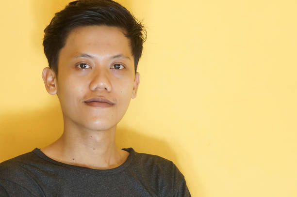 istock Smiling young Asian man wearing a black t-shirt while looking at the camera 2169554140