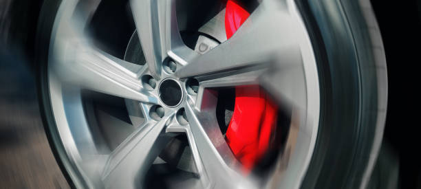istock Fast moving car wheel with red brake close up 2169557975