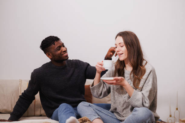 istock Joyful multiethnic couple with coffee relaxing on bed in bedroom 2169558683