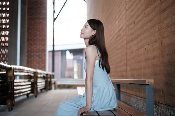 Young woman sitting quietly on a bench in a corridor