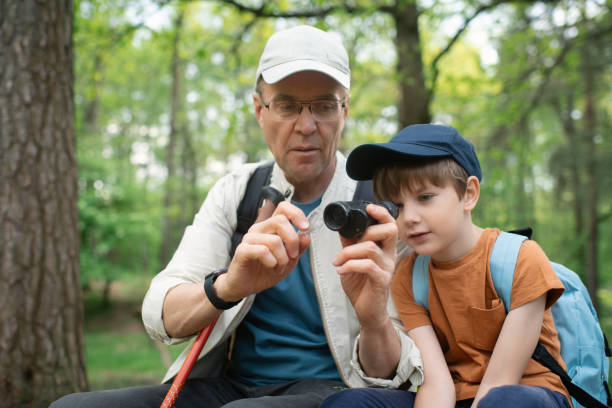 istock Little boy with his grandfather exploring nature in a forest 2169565231