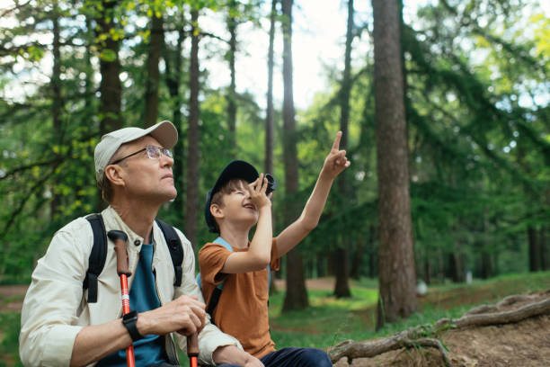 istock Little boy with his grandfather exploring nature in a forest 2169565261