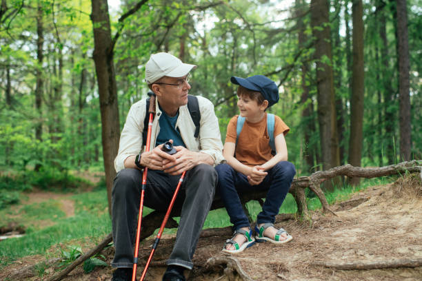 Little boy with his grandfather exploring nature in a forest