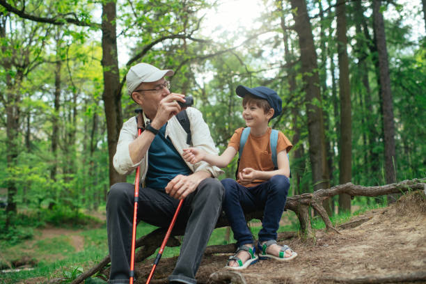 istock Little boy with his grandfather exploring nature in a forest 2169565399