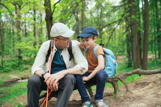 istock Little boy with his grandfather exploring nature in a forest 2169565400