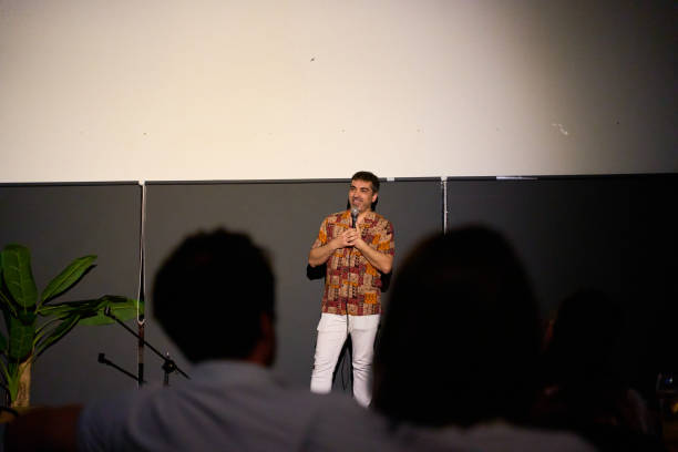istock Male performer delivering a monologue on stage in a dimly lit theater with audience 2169565897