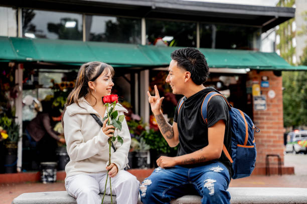 Deaf young couple talking using sign language in the city