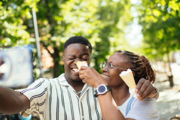 istock Young couple with ice-cream making selfie with smartphone outdoors in summer 2169576136