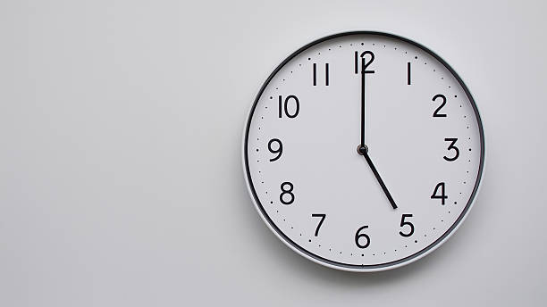 istock Minimalist Analog Wall Clock with White Face and Simple Black Hands Showing 17.00/05.00 - Ideal for Time Management and Modern Decor Concepts 2169589316