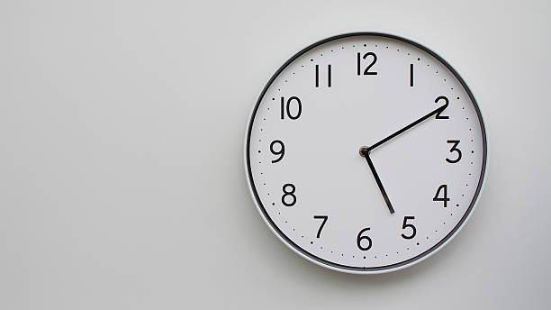 istock Minimalist Analog Wall Clock with White Face and Simple Black Hands Showing 17.10/05.10 - Ideal for Time Management and Modern Decor Concepts 2169589410