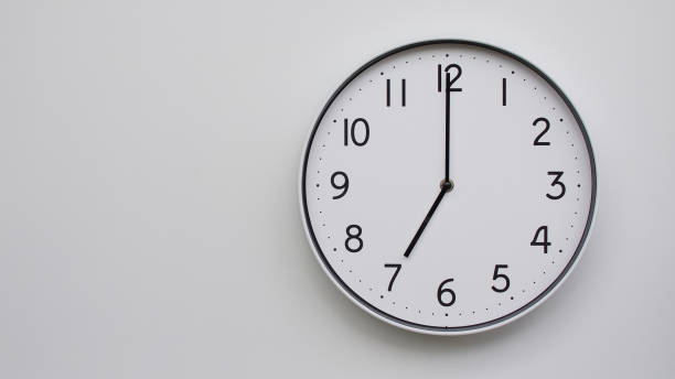 istock Minimalist Analog Wall Clock with White Face and Simple Black Hands Showing 19.00/07.00 - Ideal for Time Management and Modern Decor Concepts 2169589791