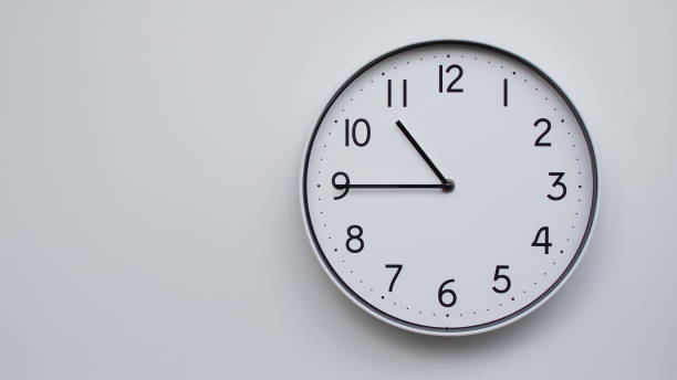istock Minimalist Analog Wall Clock with White Face and Simple Black Hands Showing 22.45/10.45 - Ideal for Time Management and Modern Decor Concepts 2169590985