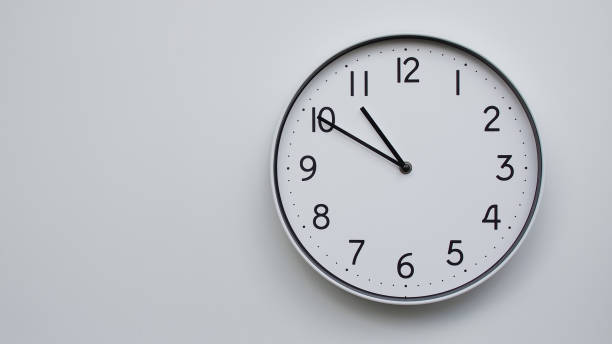 istock Minimalist Analog Wall Clock with White Face and Simple Black Hands Showing 22.50/10.50 - Ideal for Time Management and Modern Decor Concepts 2169590987