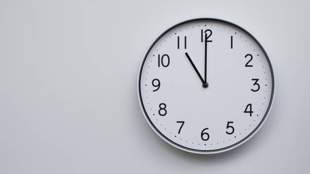 Minimalist Analog Wall Clock with White Face and Simple Black Hands Showing 11.00/23.00 - Ideal for Time Management and Modern Decor Concepts