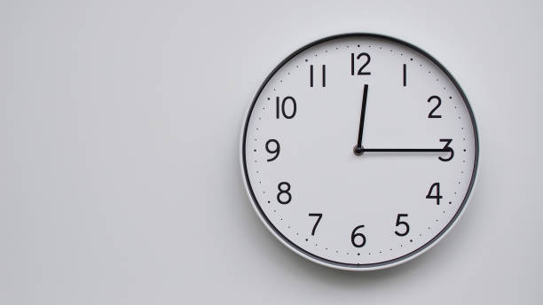 istock Minimalist Analog Wall Clock with White Face and Simple Black Hands Showing 12.15/00.15 - Ideal for Time Management and Modern Decor Concepts 2169591023
