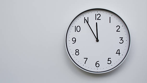 istock Minimalist Analog Wall Clock with White Face and Simple Black Hands Showing 23.55/11.55 - Ideal for Time Management and Modern Decor Concepts 2169591026