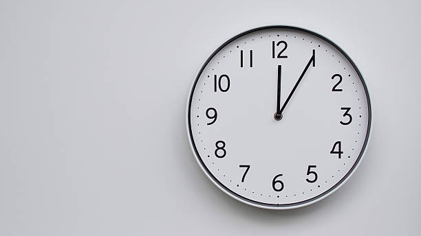 istock Minimalist Analog Wall Clock with White Face and Simple Black Hands Showing 12.05/00.05 - Ideal for Time Management and Modern Decor Concepts 2169591037