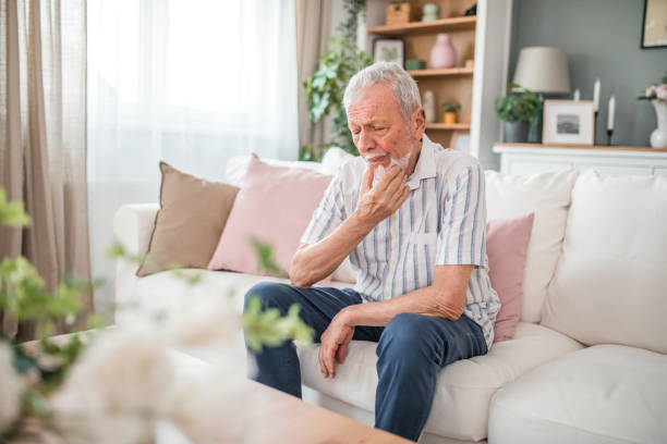 istock A mature man has a severe toothache while sitting in the living room 2169601333