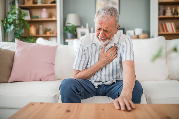 istock Elderly man suffering from chest pain while sitting on sofa at home 2169603499