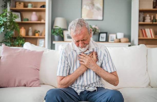 istock Senior man suffering from chest pain while sitting on sofa at home 2169604303