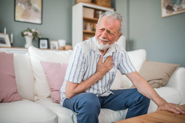 istock Senior mature man suffering from chest pain while sitting on sofa at home 2169604479