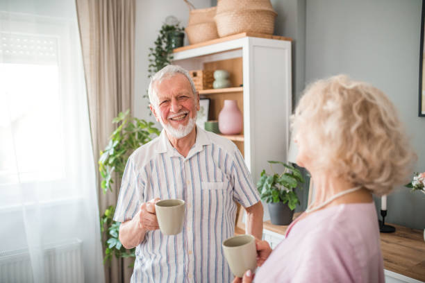istock Smiling senior couple relaxes at home drinking coffee and casually chatting 2169608651
