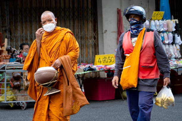 Hatyai, Thailand - Aug 26, 2024: Monks go about for alms Kim Yong fresh market, Thailand.