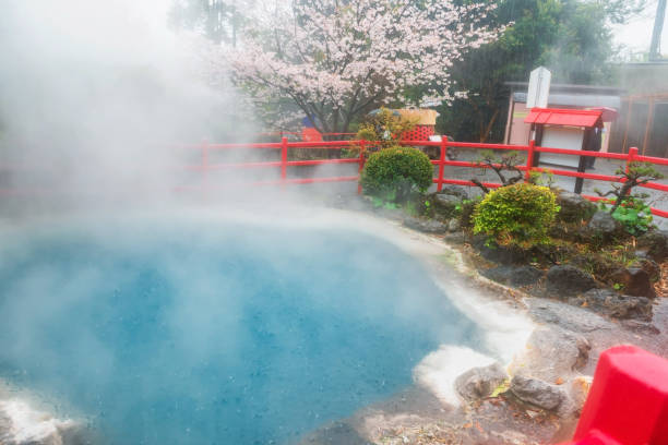 istock Kamado Jigoku blue hot spring with rain, steam and sakura, Beppu 2169612256