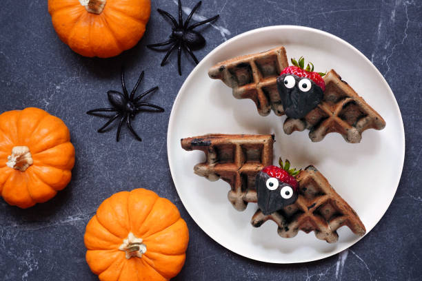 Spooky Halloween chocolate bat waffles on a dark stone table