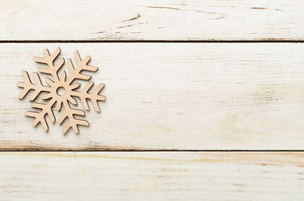 istock Beautiful snowflake on woden background, top view 2169618145