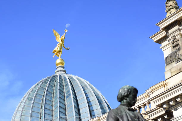 istock Angel statue on building with moon directly over her trumpet 2169621268