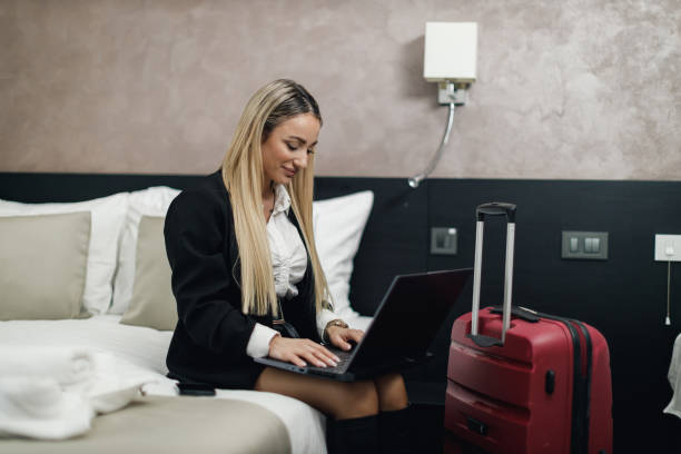 istock Businesswoman using a laptop in a hotel room 2169621507