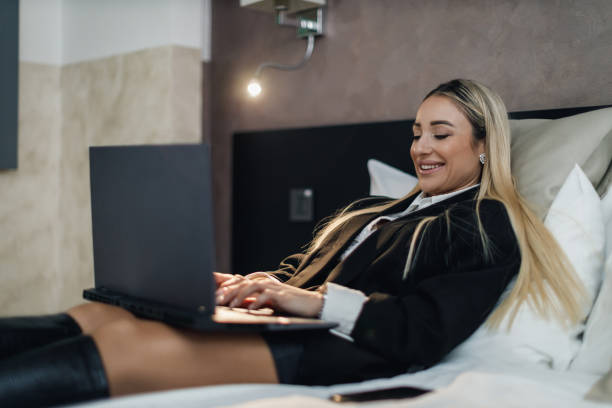 istock Businesswoman using a laptop in a hotel room 2169621804