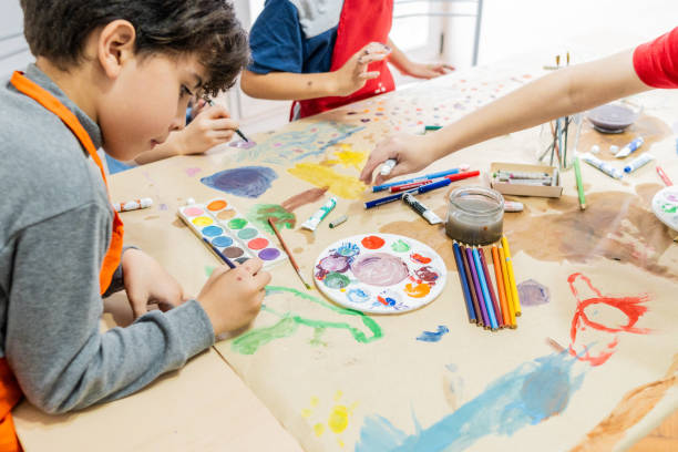 Child boy doing painting activity at school