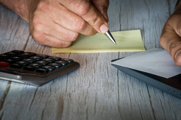 Human hand with paperslip and computer and calculater for business and office purposes