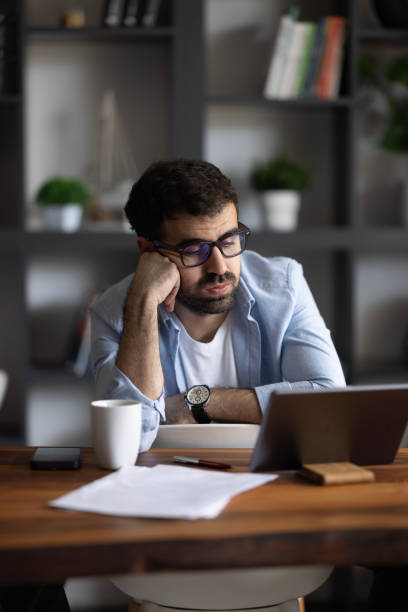 istock Confised man working on laptop at home 2169633611