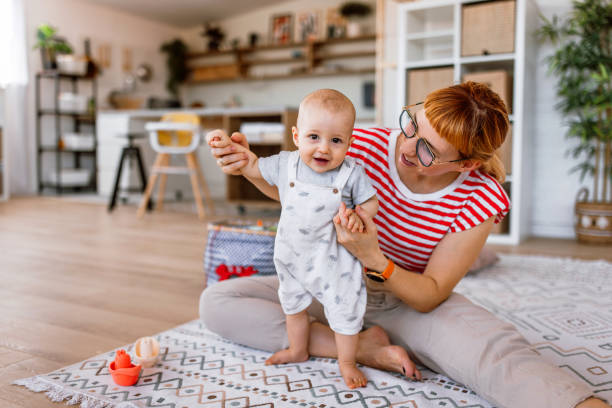 istock Mother supporting his son to take the first steps at home 2169633842