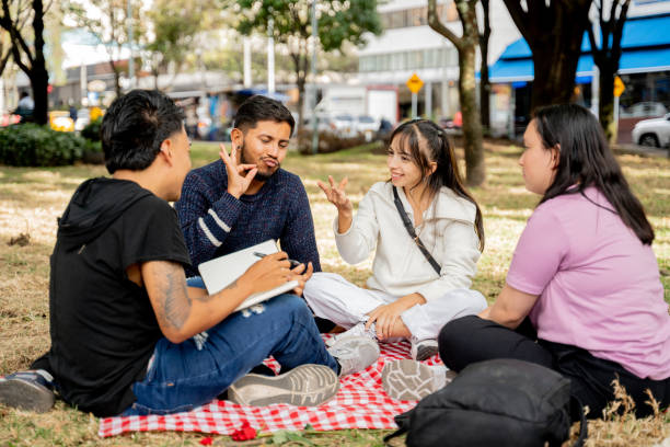 istock Deaf students communicating in sign language on the public park 2169635484