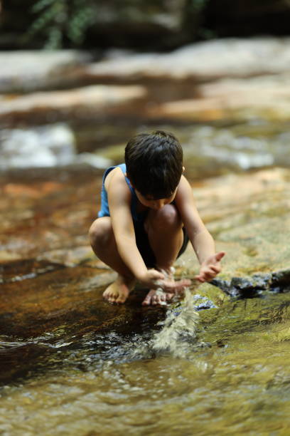 istock The boy play at the waterfall 2169637200