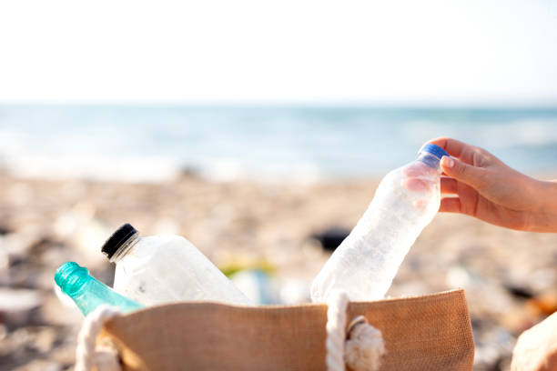 picking up plastic garbage on a beach. Plastic pollution and global ocean ecological and environment problems concept.