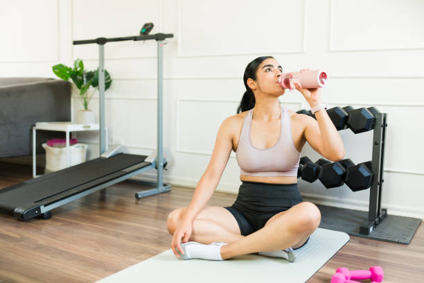istock Active woman hydrating after a home workout, pausing her fitness routine 2169638099