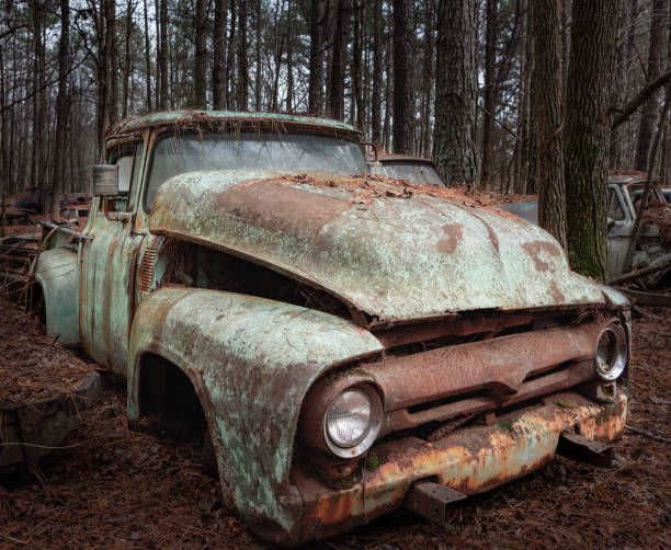 istock Rusty, decaying mint truck with no tires in woods 2169645220