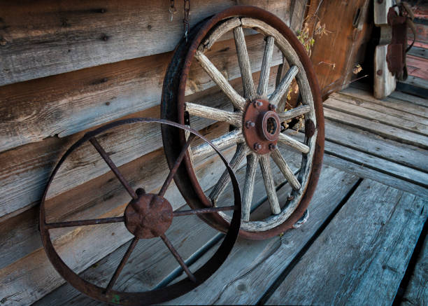 An antique wheel sits abandoned in a field. This old wheel is a reminder of technology from days gone by.